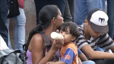 venezolansk kvinna med sitt barn