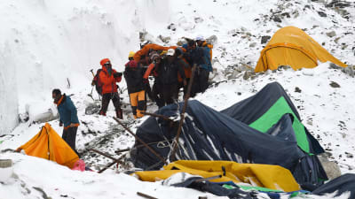 Räddningsarbetare bär de som skadats i lavinerna som utlöstes efter jordbävningen i Nepal.