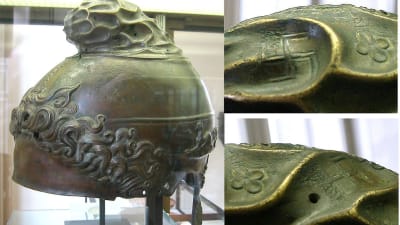 en gammal grekisk hjälm i brons med svastikasymboler på sig.