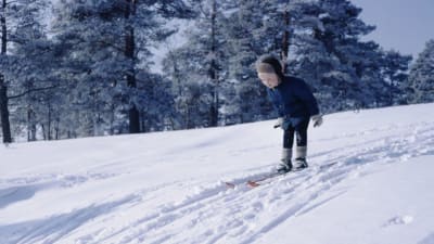Pekka Lundmark som barn åker skidor i en backe. 