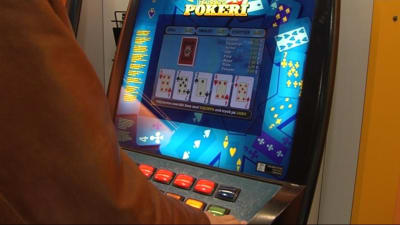 Anonym person spelar poker på en penningautomat