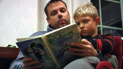 Pappa Johan Lindberg och pojken Adrian Lindberg sitter tillsammans och läser