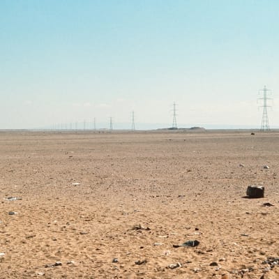 Aavikkomaisema Abu Dhabissa, voimalinja horisontissa