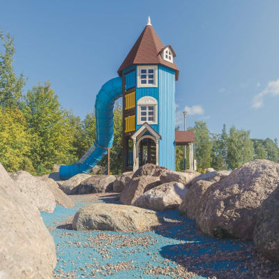 Ett muminhus med rutchbana i en lekpark.