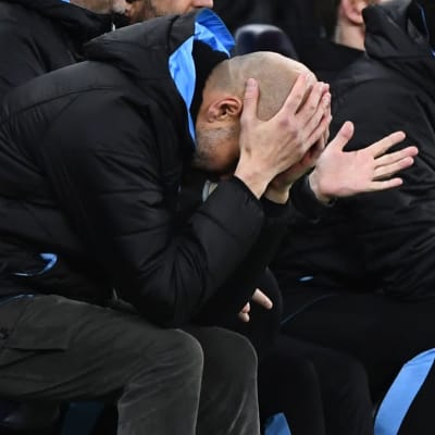 Pep Guardiola böjer huvudet neråt.