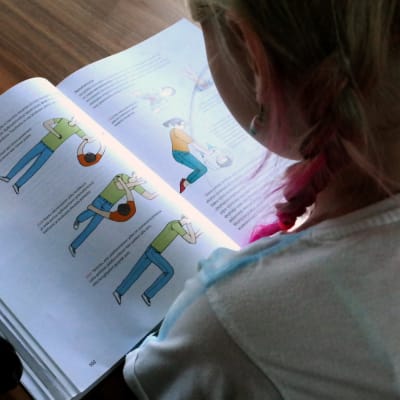 Tyttö lukee oppikirjaa