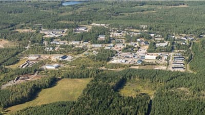 Ett flygfoto över ett planerat industriområde. Skog och byggnader, åkrar.