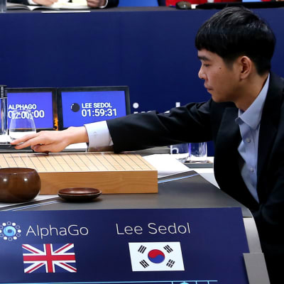 En av världens bästa Go-spelare, Lee Se-dol, placerar sin första spelpjäs på spelbredän då han inleder den tredje matchen mot datorprogrammet AlphaGo.den 12 mars i Seoul.