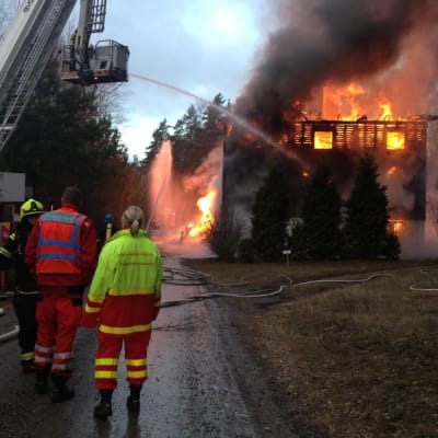 Räddningsmanskap arbetar vid ett brinnande hus.