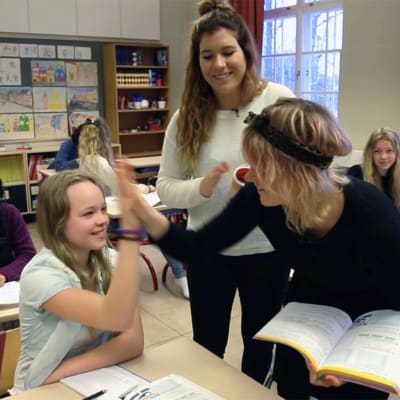 Frida gör high five med en elev.