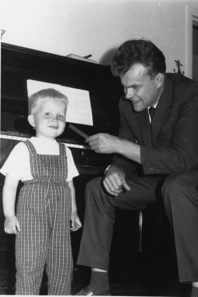 Sören Lillkung som barn tillsammans med sin pappa vid ett piano.