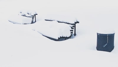 Parkbänkar intäckta i snö