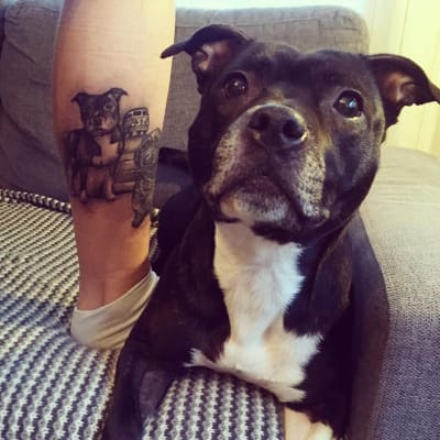Tatuering som föreställer en hund med en äkta hund bredvid.