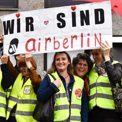 Airberlinin henkilökuntaa osoittamassa mieltään ja nostamassa kylttiä jossa lukee "Wir sind Airberlin" tänään Berliinissä.