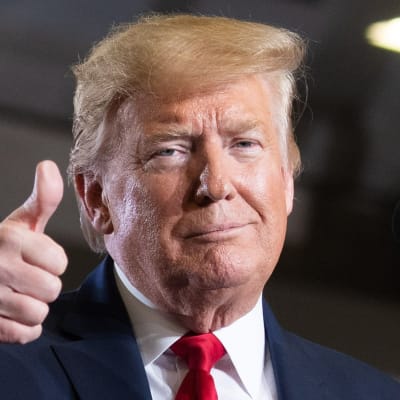 Donald Trump tittar in i kameran och håller upp ena tummen. 