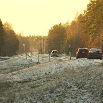 Tre bilar kör på en landsväg på vintern.