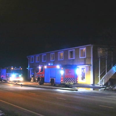 Två brandbilar utanför ett hus.