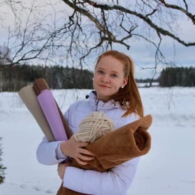 Tyttö pitää sylissään keppihevosen tekoon tarvittavia välineitä. 