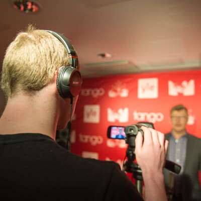 Kilpailija laulaa videokameralle tangomarkkinoiden esikarsintakiertueella Helsingissiä