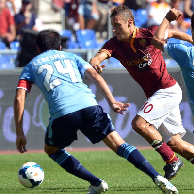 Lazion Cristian Ledesma ja Hernanes yrittävät pysäyttää Roman Francesco Tottin.
