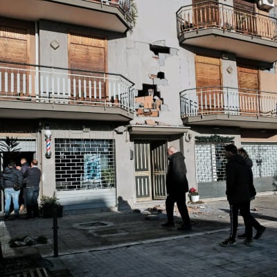 Invånare beskådar en byggnad i Zafferana Etnea nära Catania efter jordskalvet 26.12.2018  