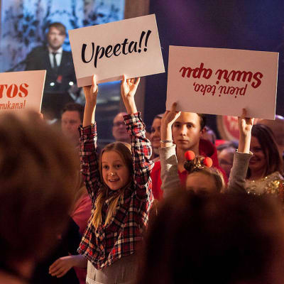 Publik på Yles Näsdagsshow 2016 som håller upp skyltar där det bland annat står: "Tack för att du är med".