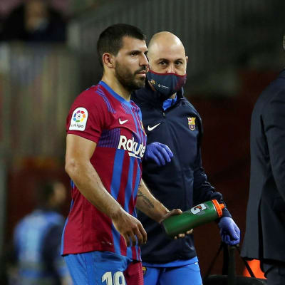 Sergio Aguero poistuu kentältä valmentajan saattelemana kasvoillaan vakava ilme.