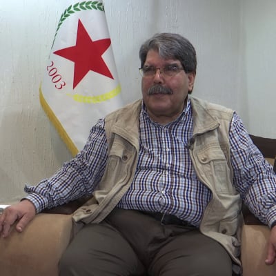 Salih Muslim istuu sohvalla