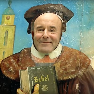 Mark Levengoods ansikte bakom en pappfigur av Marthin Luther.