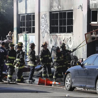 Palomiehet raivasivat tulipalossa tuhoutunutta varastoa joulukuussa 2016.