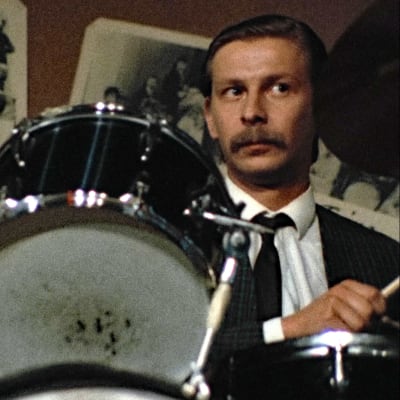 Matti Pellonpää soittaa rumpuja tv-elokuvassa Onnentyttö (1982).