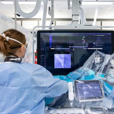 Kardiologi ja sairaanhoitaja tekevät sydänpotilaalle sepelvaltimoiden varjoainekuvausta Tays Sydänsairaalan toimenpidesalissa.