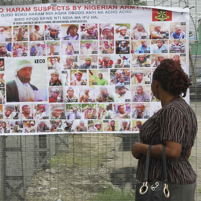 En nigeriansk kvinna ser på en plansch med bilder på misstänkta och efterlysta medlemmar av Boko Haram