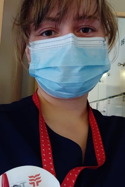 Sjukskötare med ansiktsmask och arbetskläder 