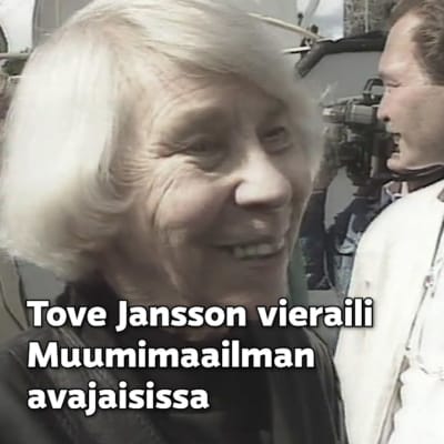 Tove Jansson hymyilee. Otsikko: "Tove Jansson vieraili Muumimaailman avajaisissa".