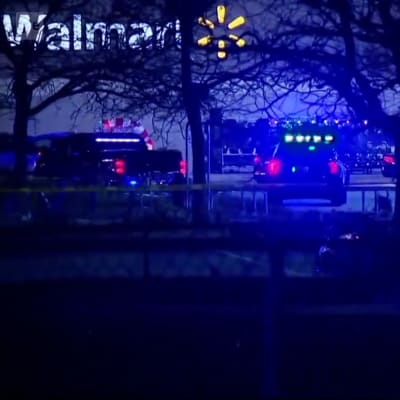Polisbilar och -tejp framför en byggnad med en stor skylt där det står Walmart.