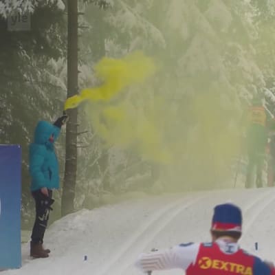 Mielenosoittaja levittää hiihtoladulla keltaista savua.