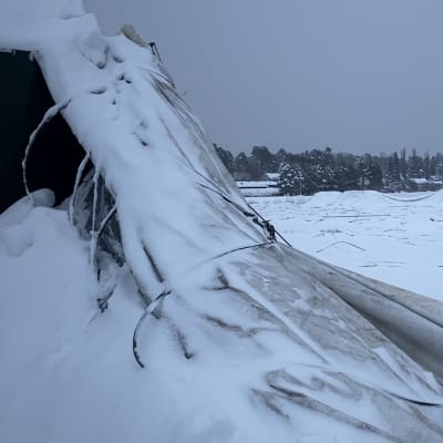 Lumen alta pikistää romahtaneen kuplahallin rakenteita ja perssua kentän päällä.
