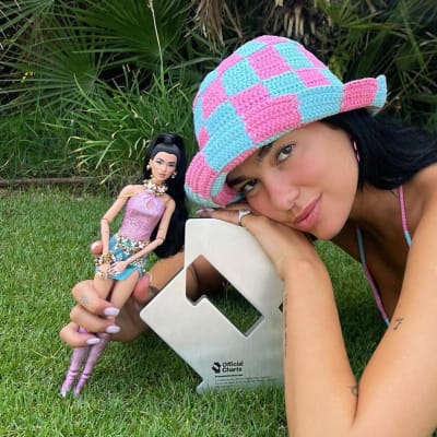 Artisten Dua Lipa i bikini på en gräsmatta.