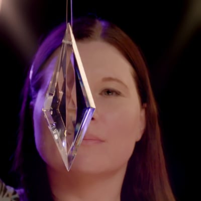 Hypnoterapeutti ja psykologi Pia Puolakka katsoo kristallia.