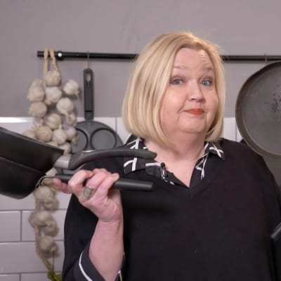 Puoli seitsemän -ohjelman toimittaja Regina Rask seisoo keittiössä ja hänellä on käsissään erilaisia naarmuuntuneita paistinpannuja. 