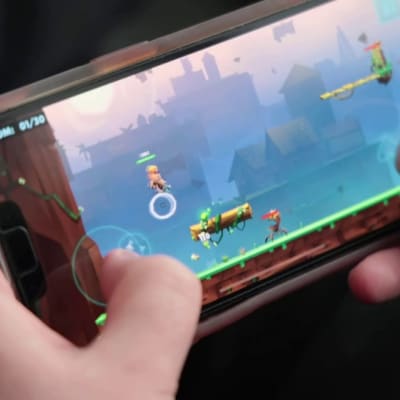 Mobilspel: två händer håller en mobil på tvären och spelar ett av Nitro Games spel.
