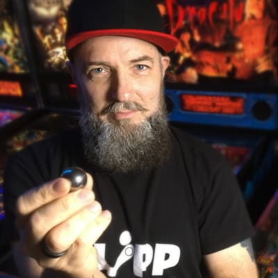 Marco Suvanto seisoo flipperien edessä kädessään flipperin kuula.