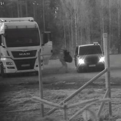 En personb bär en väska från en långtradare till en taxi.
