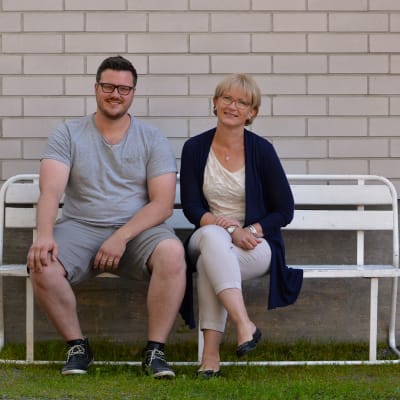 Robert Louhimies och Ulrica Isaksson sitter på en bänk.