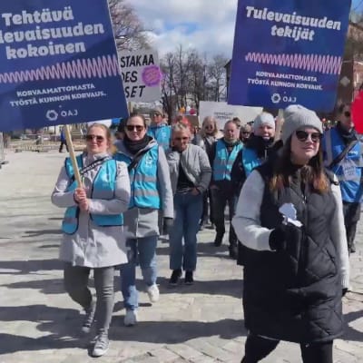 Kunta-alan mielenosoittajia kylttien kanssa Turun tuomiokirkon edustalla.
