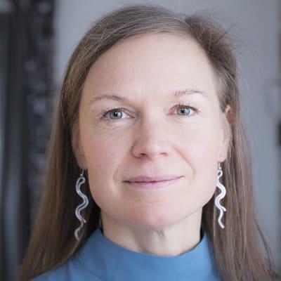 Petriikka Pohjanheimo katsoo kohti kameraa ja hymyilee vähän.