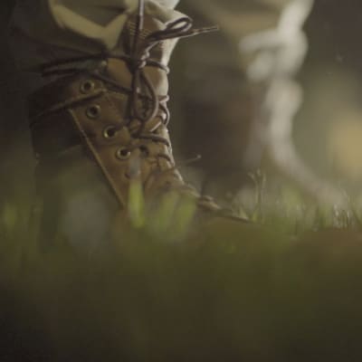 Nattlig bild av foten på en soldat som står på en gräsmatta.
