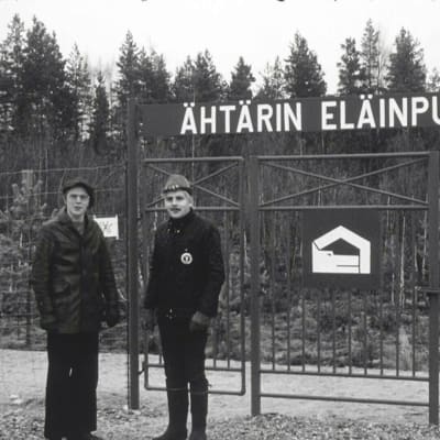 Miehet seisovat Ähtärin eläinpuiston portin edessä vuonna 1973, pysäytyskuva arkistomateriaalista.