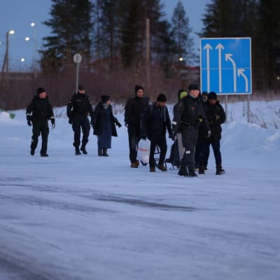 Rajavartijat saattavat turvapaikanhakijoita Vartiuksen raja-asemalla.
